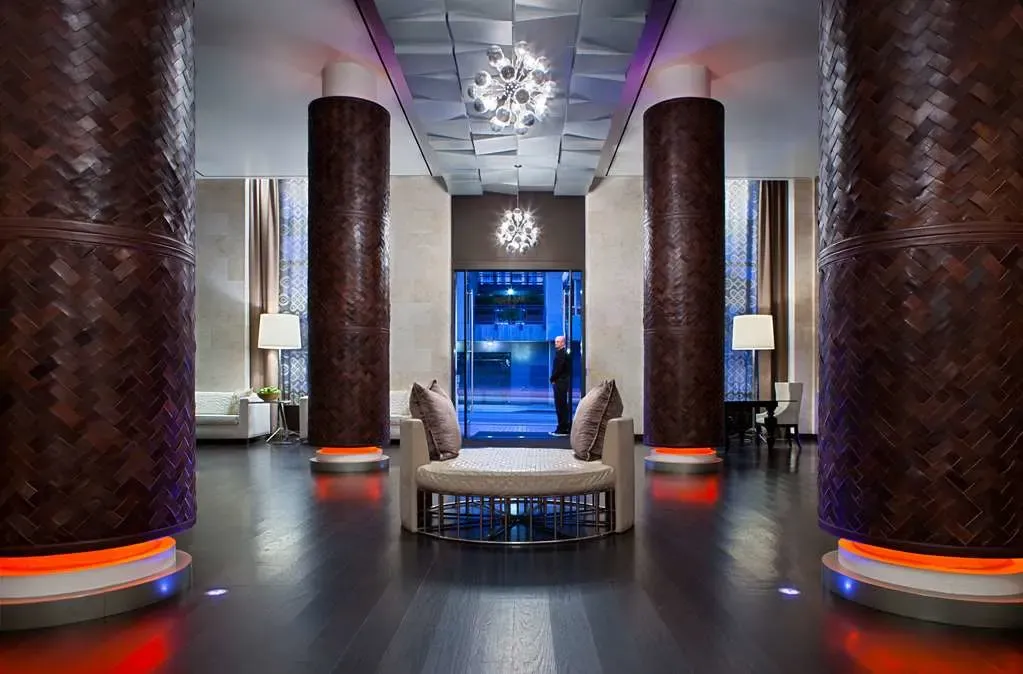 Basket-weave columns lit orange and blue above a round upholstered banquette.