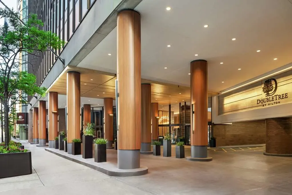 The porte-cochere entrance, wood-clad columns under a concrete canopy.
