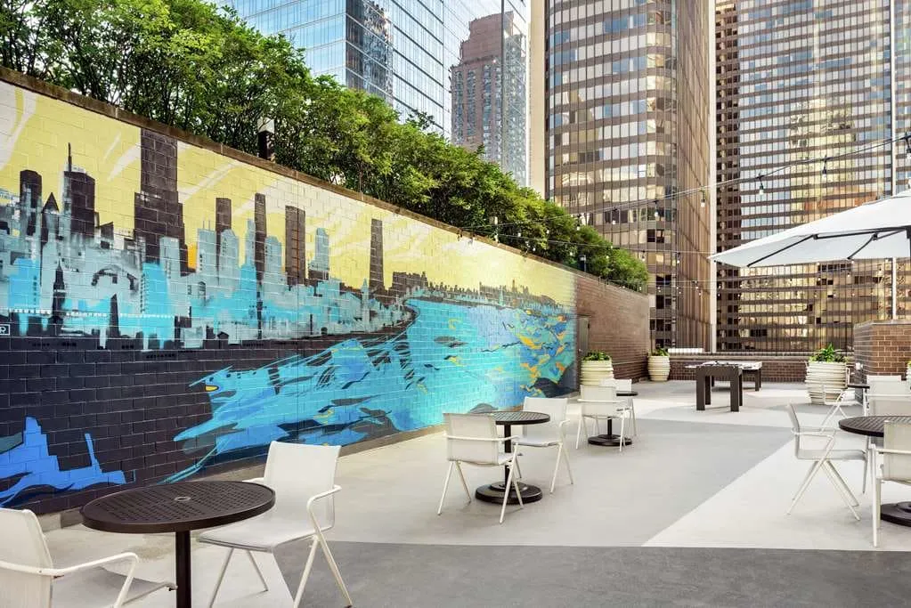 The rooftop games corner, table tennis under string lights and a skyline mural.