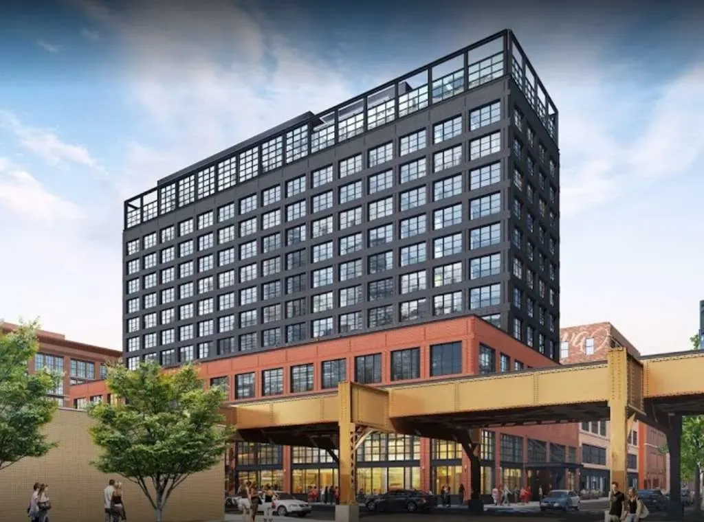 The Hoxton's dark metal tower above its red-brick base, elevated tracks crossing below.