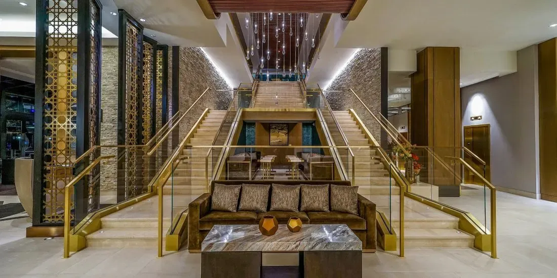 Twin staircases under a long cascade of teardrop pendants.