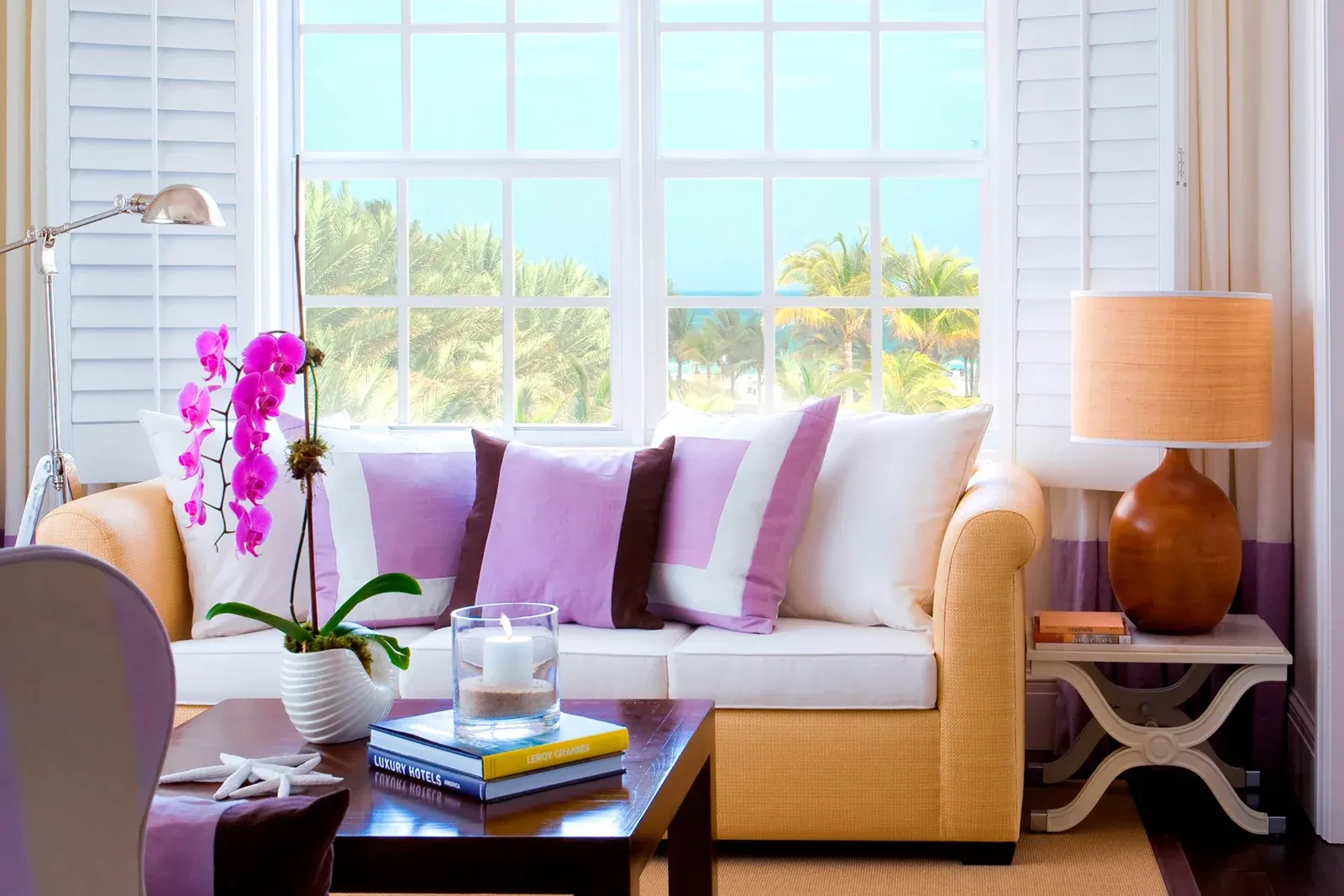 A Royal Ocean View sitting area, shutters folded back to palms and sea.