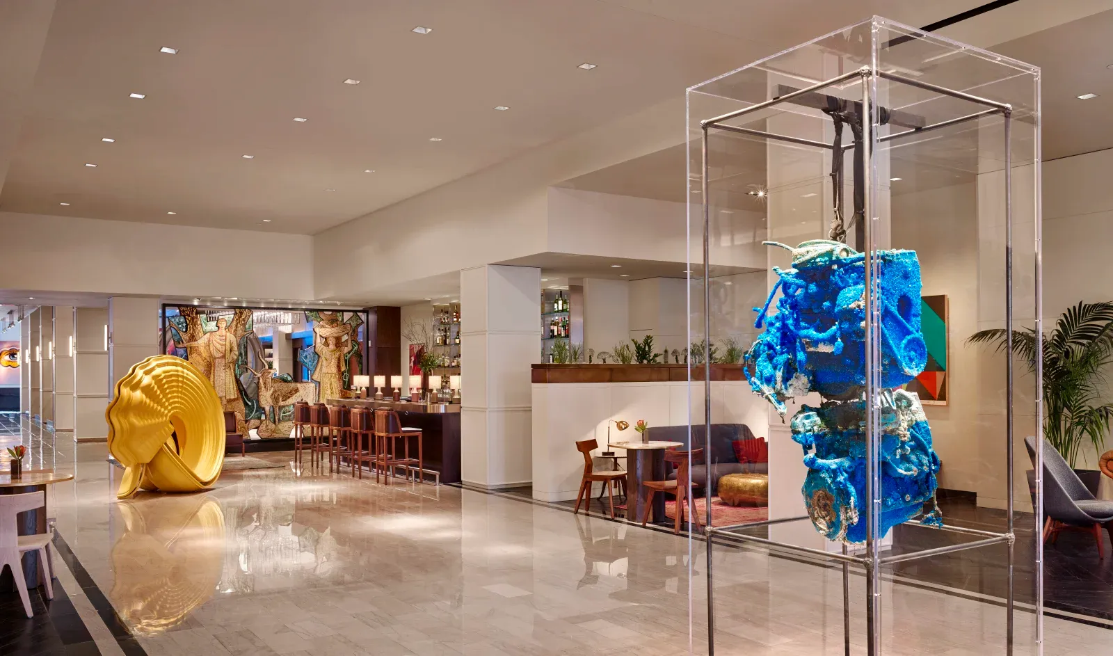 The marble lobby, a coiled gold sculpture and the bar's row of leather stools.