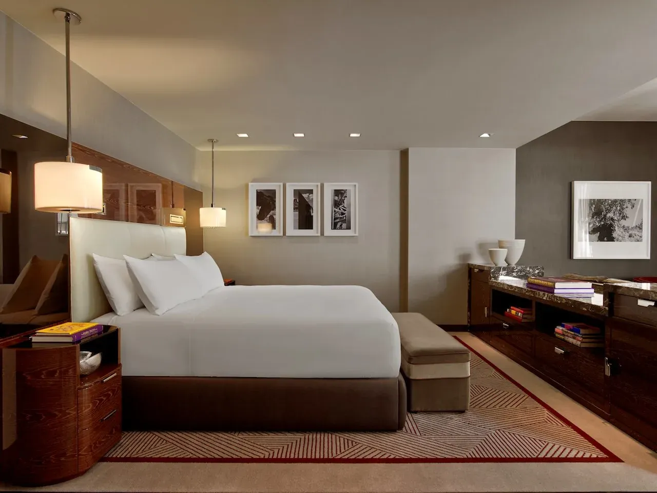 A Premier King under a cream leather headboard, velvet bench at its foot.