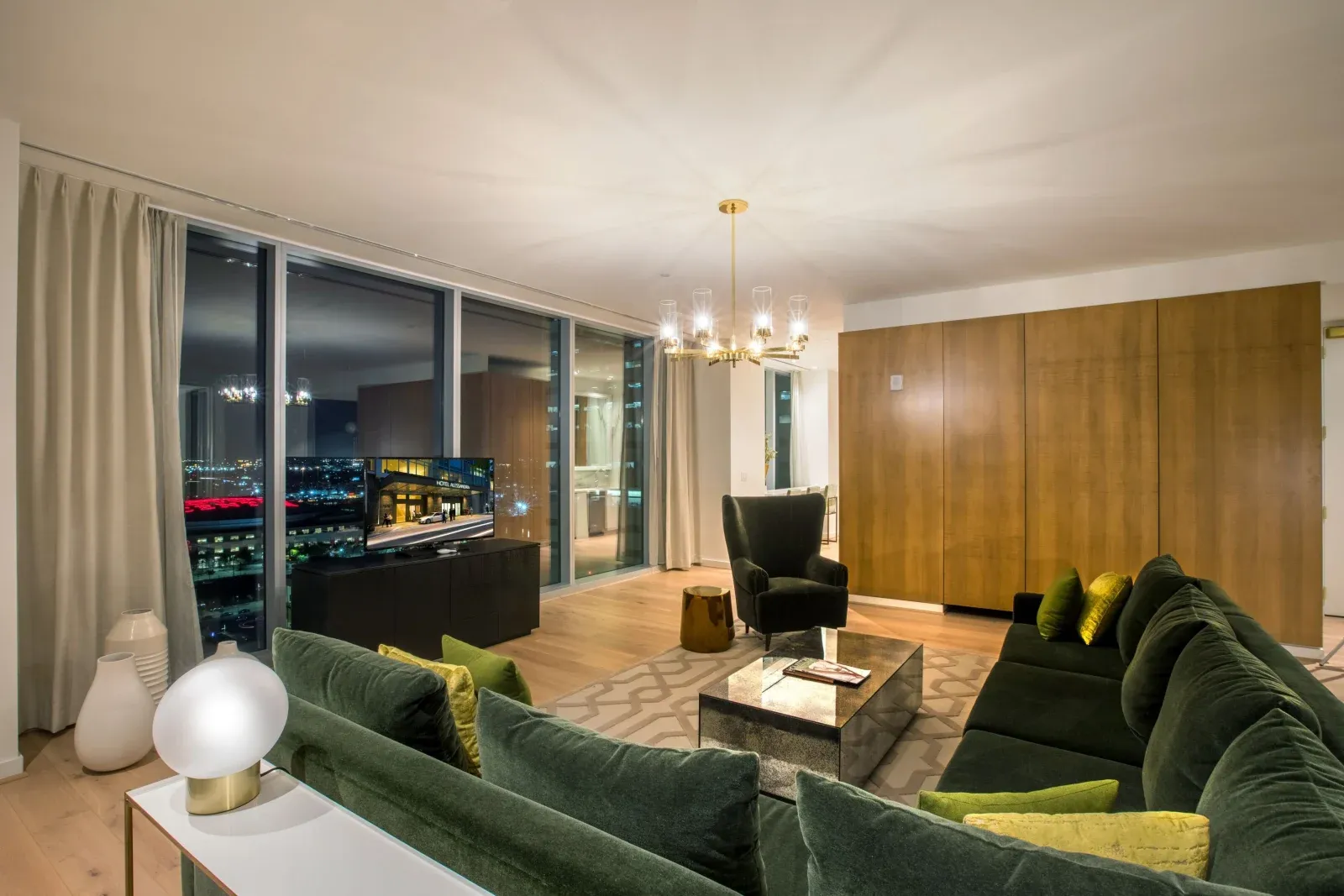 The presidential suite at night, velvet sofas facing the lit city.
