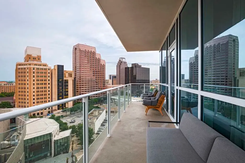 A private balcony with lounge seating, looking out over downtown San Antonio.