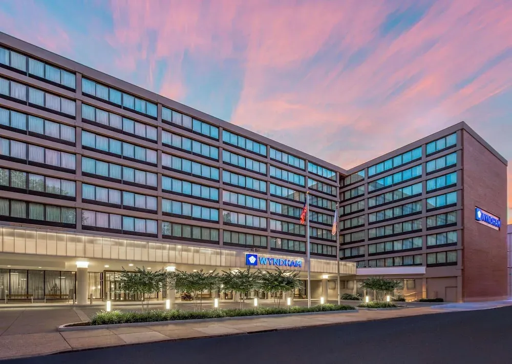 The Wyndham's mid-century block at dusk, banded windows and a pink-streaked sky.